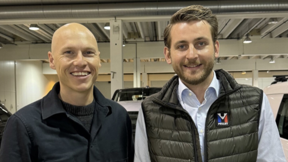 Kristoffer Due-Sørensen (sjef Gire Norge) og Mikkel Gulbrandsen (leder BCA Bilauksjon Norge) smiler på et parkeringsområde ved en bilforhandler