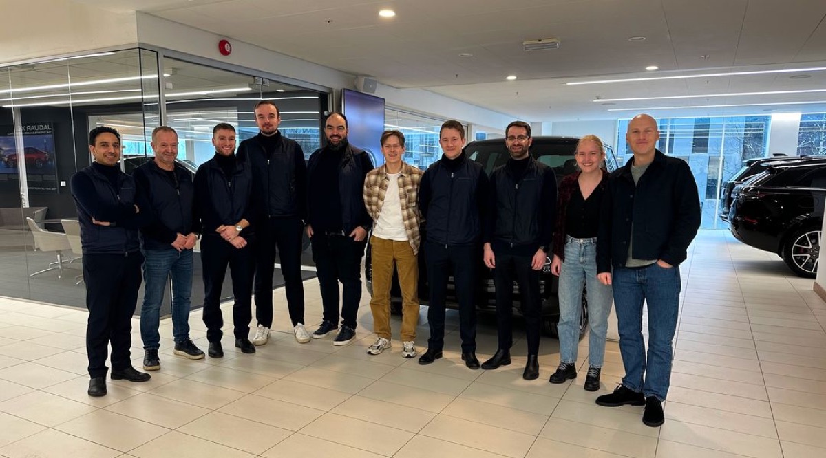 Ti personer i en lys bilsalong ved siden av en mørk SUV, Bilia Insignia og Gire