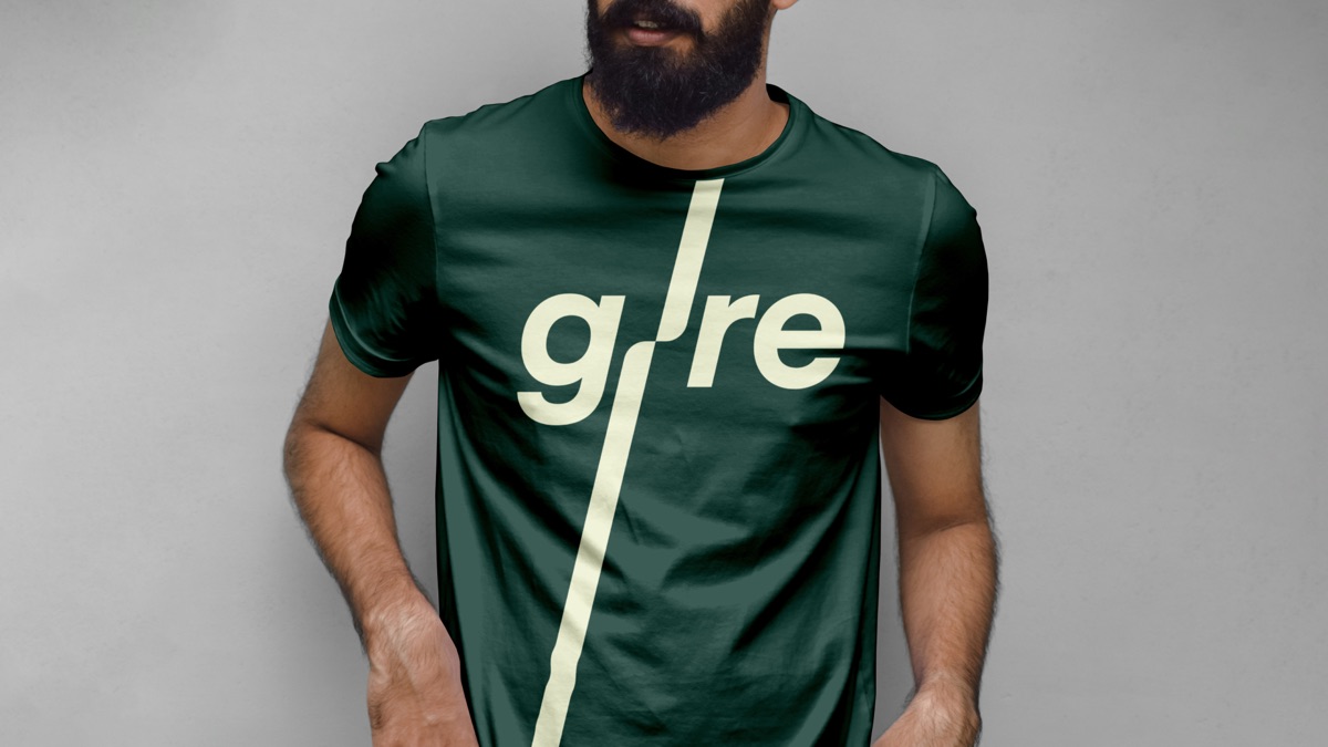 Mann i mørkegrønn Gire-t-skjorte med kremstripe og den nye Gire-logoen