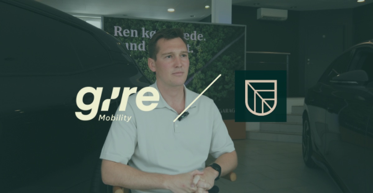 Mand der interviewes på kamera i en bilforhandler med Gire Mobility og Green Garage-logoer