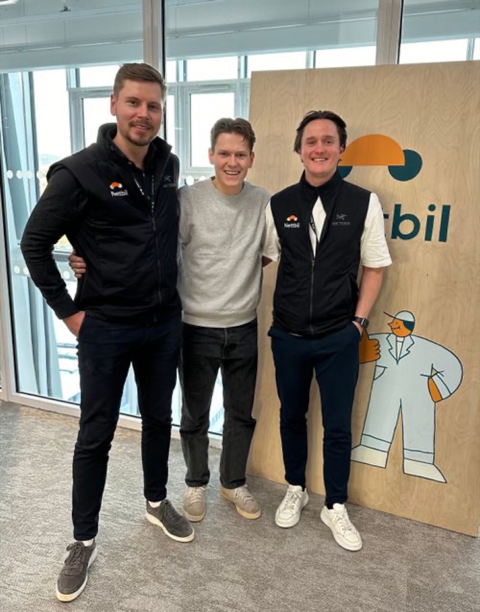 Tre menn foran et Nettbil-skilt i tre, Nettbil og Gire-samarbeid