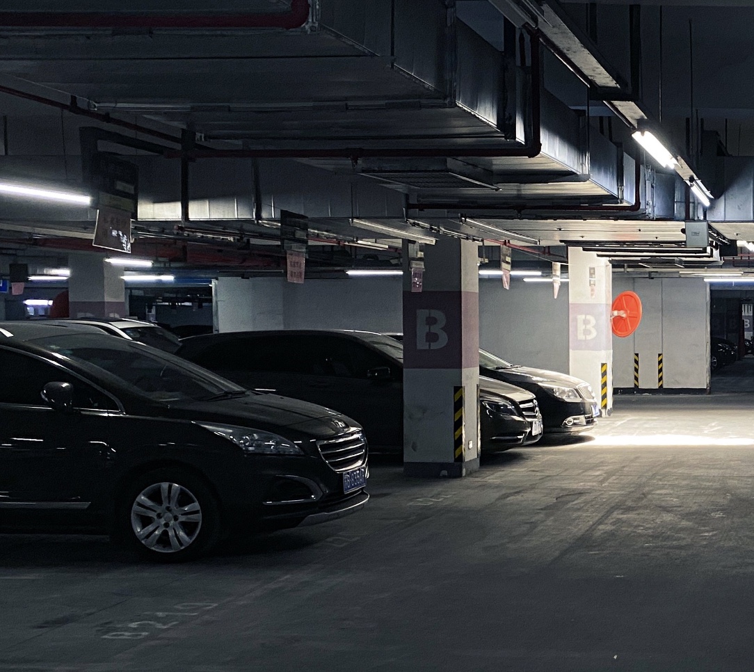 Innendørs parkeringshall med biler parkert mellom søyler